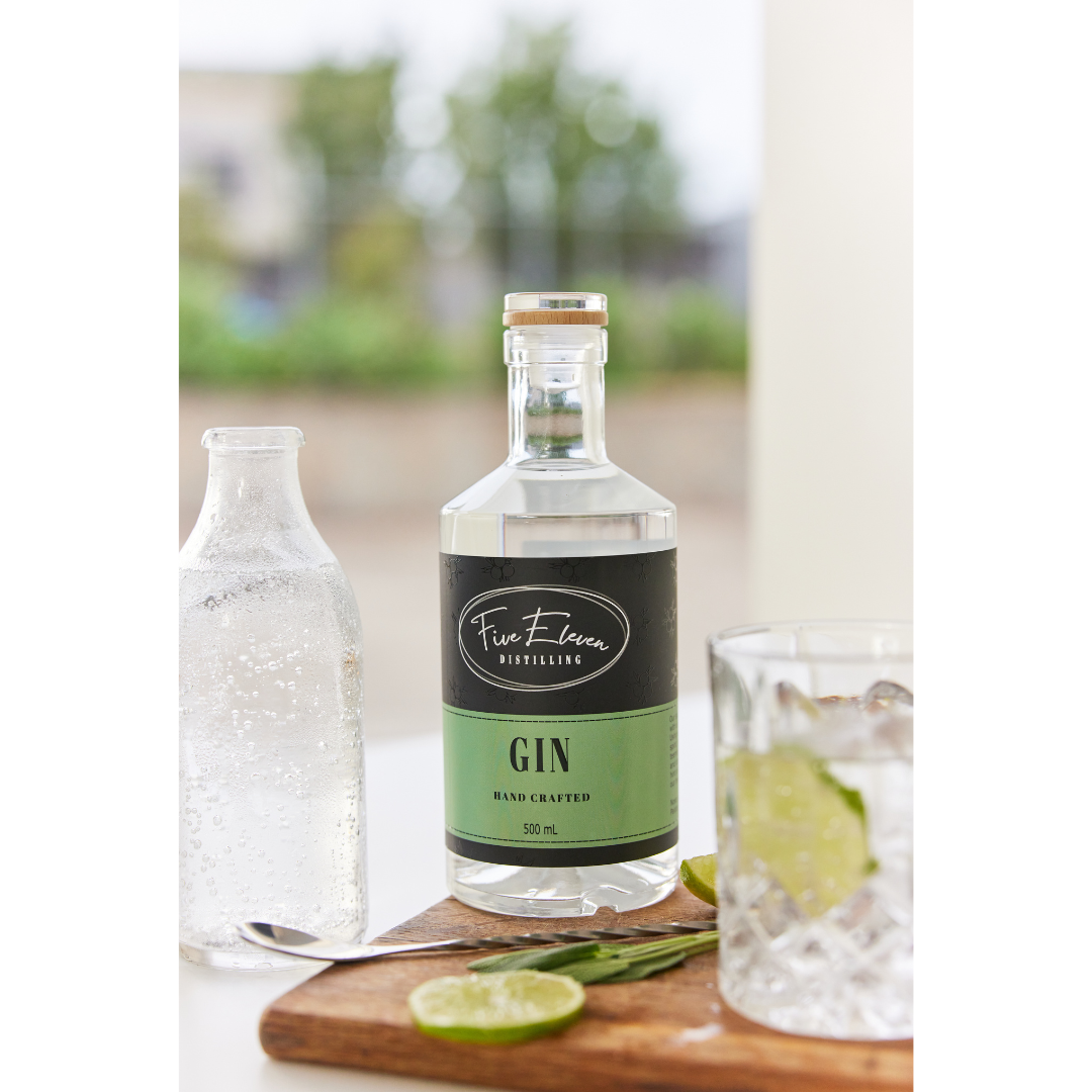 500 ml bottle of signature gin with some lime scattered on wooden board